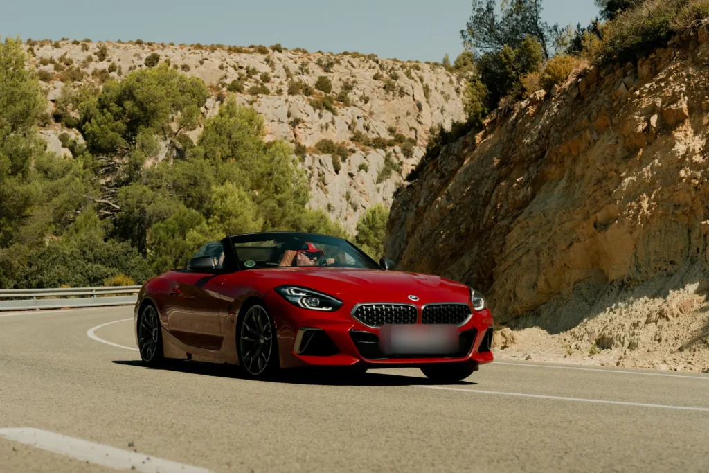 BMW Z4 rojo en curva de montaña en la ruta RX01 Serranías del Turia de Road Experience, ruta en coche deportivo por Valencia