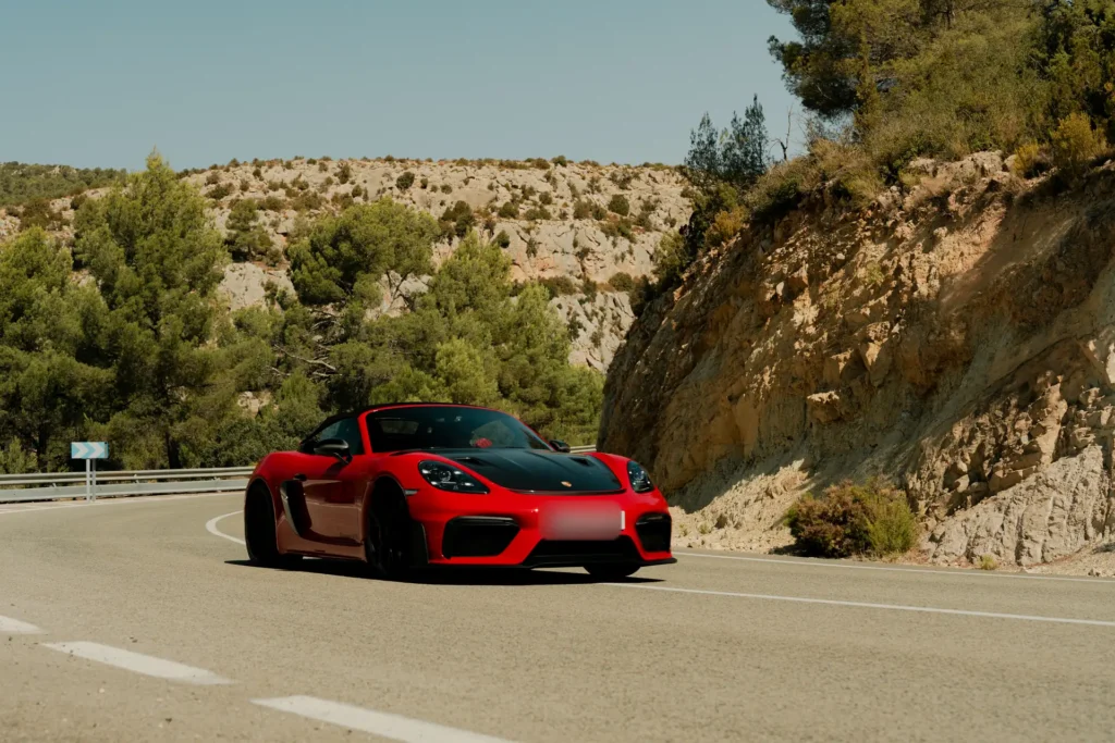 Porsche 718 GT4 RS rojo en curva en la ruta RX01 Serranías del Turia de Road Experience, ruta en coche deportivo por Valencia