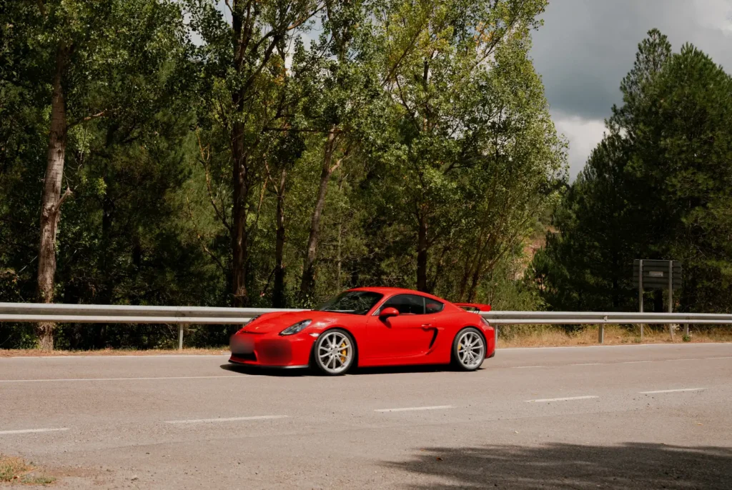Porsche 718 Cayman GT4 rojo en el pinar en la ruta RX02 Vistabella de Road Experience, ruta en coche deportivo por Castellón