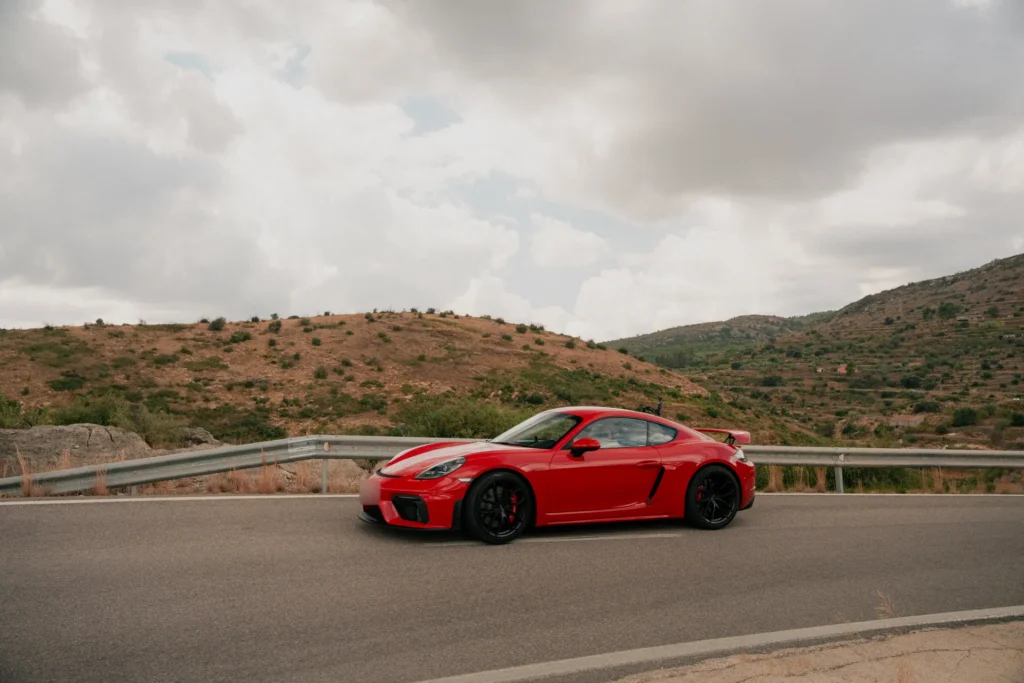 Porsche 718 Cayman GT4 rojo en la montaña en la ruta RX02 Vistabella de Road Experience, ruta en coche deportivo por Castellón