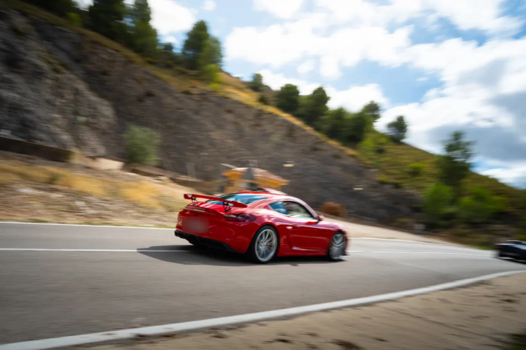 Porsche 718 Cayman rojo en curva en la ruta RX03 El Santuario de Road Experience, ruta en coche deportivo por Alicante