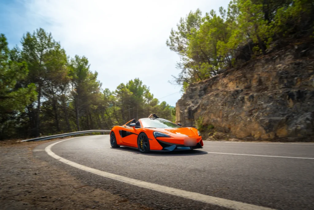 McLaren 570S naranja en curva en la ruta RX04 Villahermosa de Road Experience, ruta en coche deportivo por Castellón