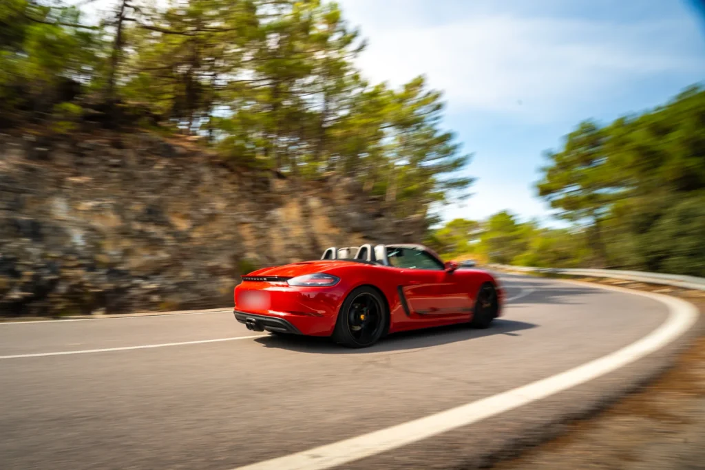 Porsche 718 rojo en curva de montaña en la ruta RX04 Villahermosa de Road Experience, ruta en coche deportivo por Castellón